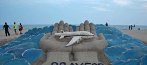 des-promeneurs-passent-sur-une-plage-a-puri-en-inde-ou-l-artiste-sudersan-pattnaik-a-sculpte-dans-le-sable-un-memorial-aux-victimes-du-vol-mh370-le-12-mars-2014_4840141