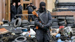 An armed man, representing Ukrainian special forces, stands guard outside the regional administration building in Kharkiv