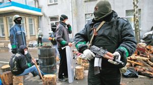 Pro-Russian armed men stand guard while pro-Russian protesters gather near the police headquarters in Slaviansk