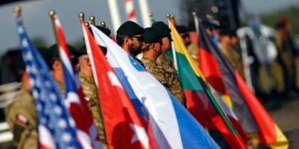 Participants hold flags of their countries during the "Noble Sword-14" NATO international tactical exercise at the land forces training centre in Oleszno
