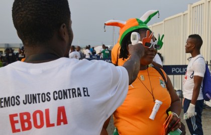 648x415_a-health-worker-checks-the-body-temperature-of-a-fan-as-part-of-an-ebola-screening-ahead-of-the-2015